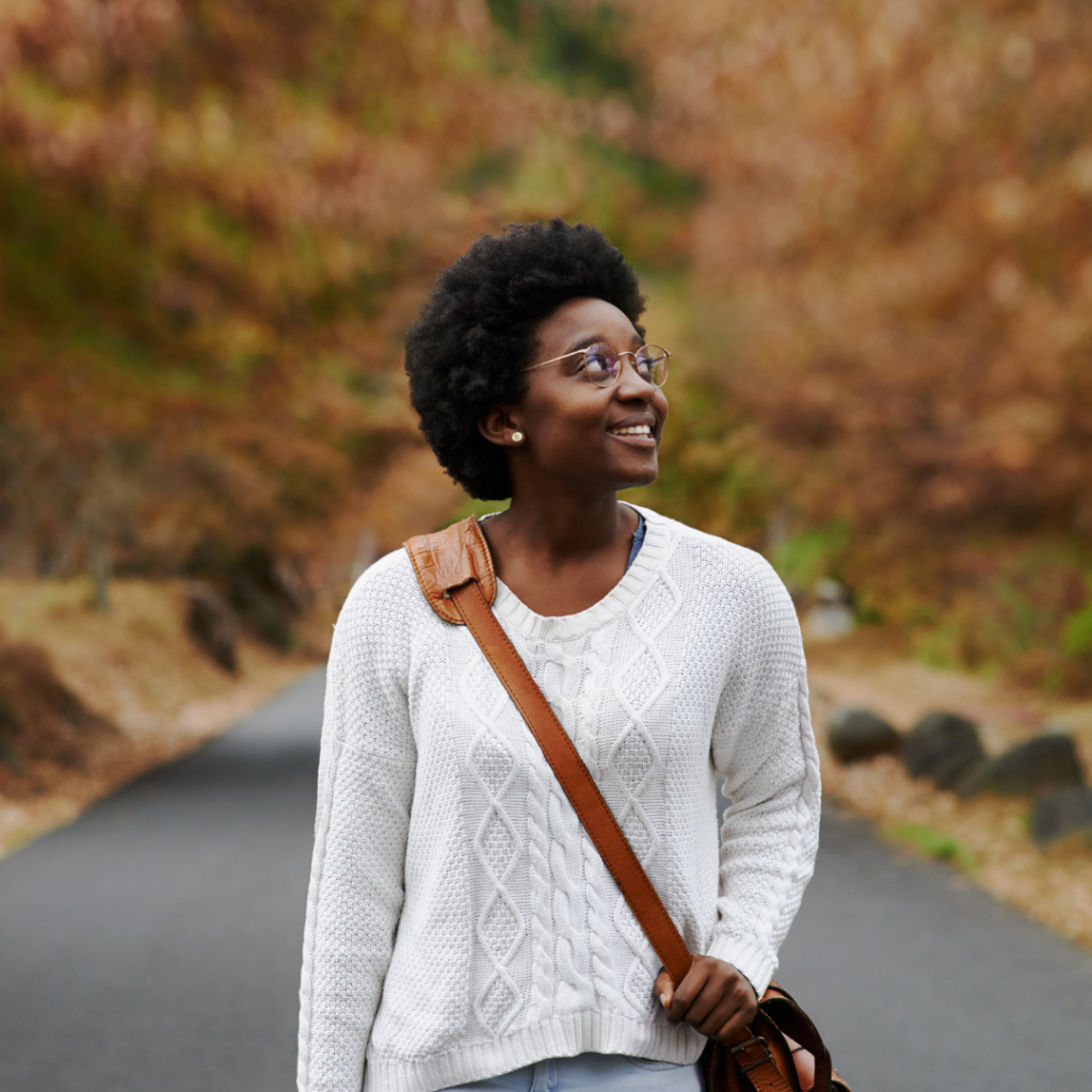 A woman confidently exploring a scenic destination, symbolizing the bold and empowering travel adventures encouraged by CDWY