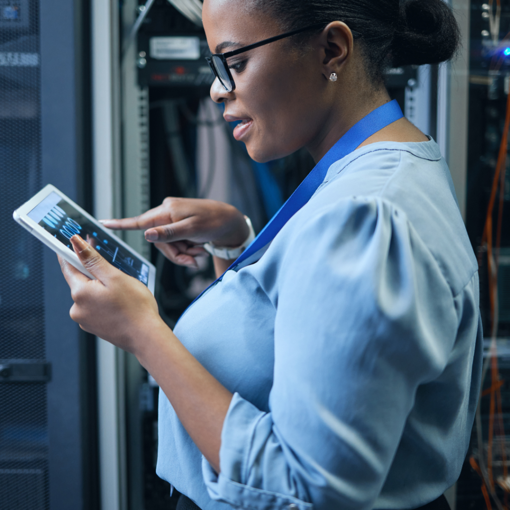 A woman confidently working on a computer, representing her role in the cybersecurity field and her contributions to the tech industry