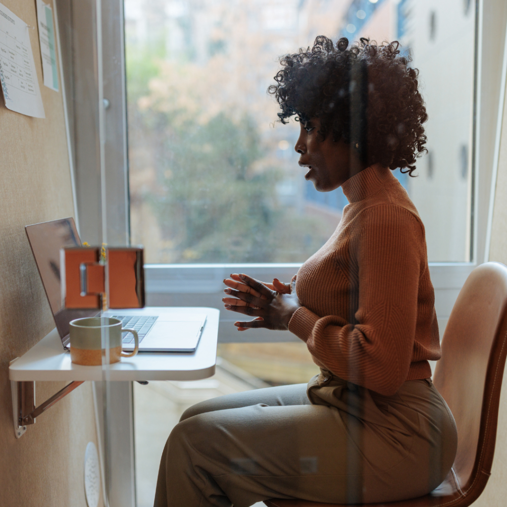 A woman participating in an online meeting, engaged in virtual collaboration and discussion.